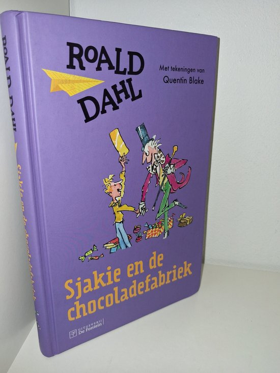 Voor- en zijkant van het boek Sjakie en de chocoladefabriek met illustraties van Willy Wonka, Sjakie en de Oempa Loempa's.