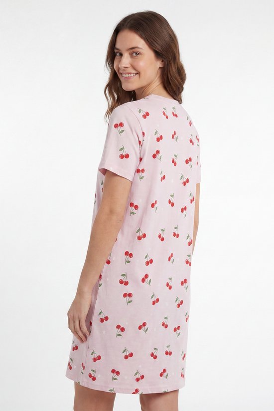 Model draait zich om, in roze nachthemd met korte mouwen en kersenprint.