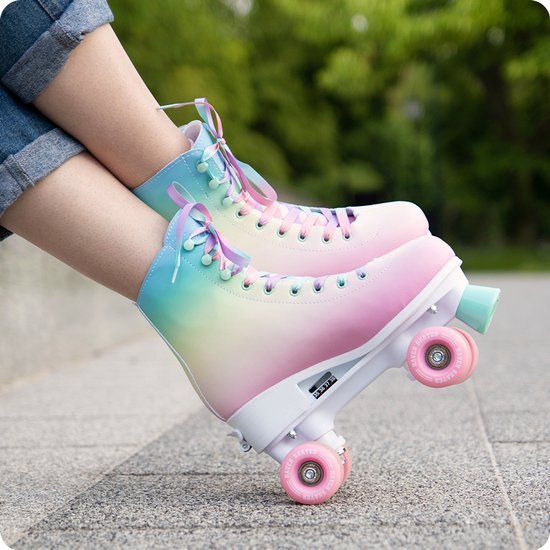 Roller skates met pastelkleurige gradiënt en paarse, roze, blauwe veters, gedragen in het gras.