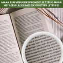 Dichtbij een open boek met grote letters, waarschijnlijk om te lezen met de loeplamp.