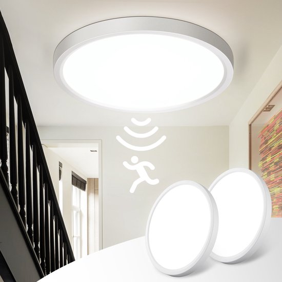 Ronde, witte Oraymin plafondlamp met bewegingssensor, gemonteerd in een gang bij een trap.
