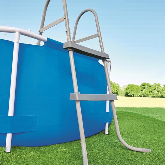 Grijze ladder bij een ronde blauwe zwembad.
