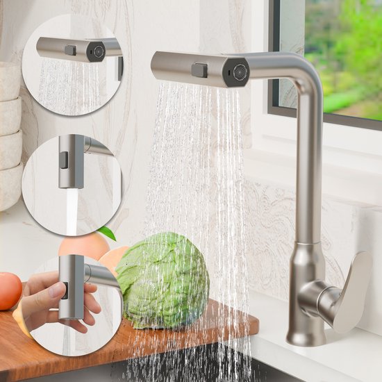 Robinet de cuisine en acier inoxydable gris avec douchette extractible, projetant de l'eau. Un chou et des pêches se trouvent sur une planche à découper en bois. De petites images montrent différents modes de pulvérisation.