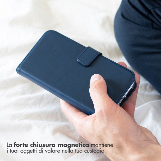 Blauw lederen telefoonhoesje met magnetische sluiting, vastgehouden door een hand.
