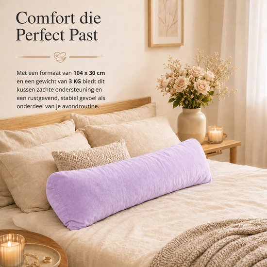 Een paars langwerpig kussen ligt op een opgemaakt bed met beige lakens en sierkussens.