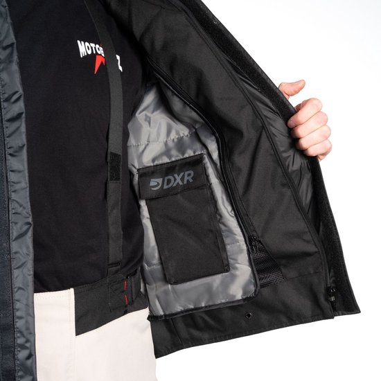 Binnenkant van een zwart motorjack, met zak met DXR logo.