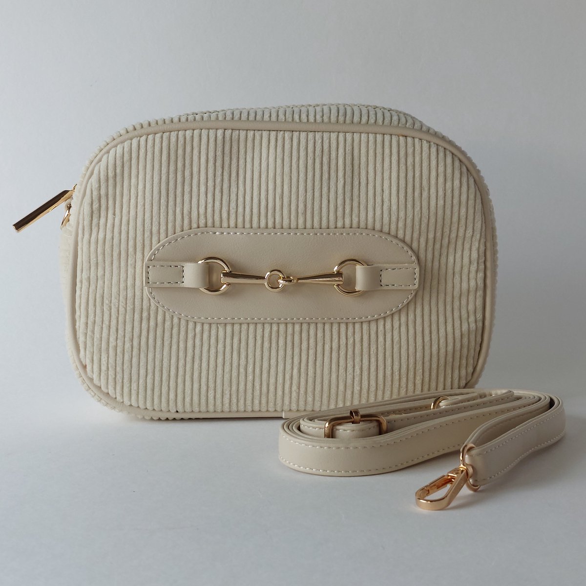 ribstof crossbody tas dames crème - ovale schoudertas met messing details - compacte trendy handtas - zachte rib stof crossbody stijl