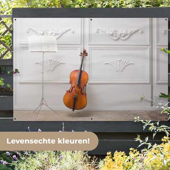 Tuinposter 180x120 cm - Tuindecoratie Een cello tegen een witte muur - Poster voor in de tuin - Buiten decoratie - Schutting tuinschilderij - Tuindoek muurdecoratie - Wanddecoratie balkondoek