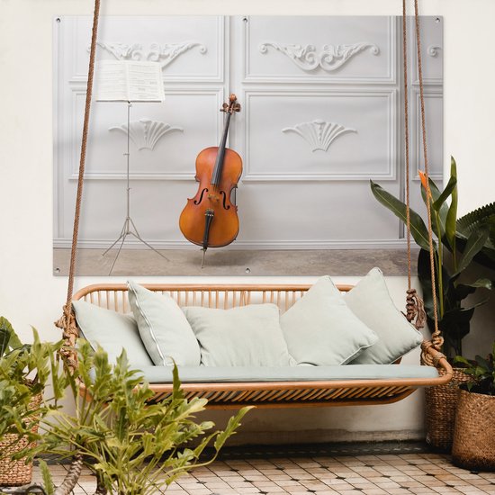 Tuinposter 180x120 cm - Tuindecoratie Een cello tegen een witte muur - Poster voor in de tuin - Buiten decoratie - Schutting tuinschilderij - Tuindoek muurdecoratie - Wanddecoratie balkondoek