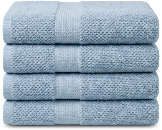 Pile de serviettes bleu clair avec une texture tricotée et un motif gaufré.