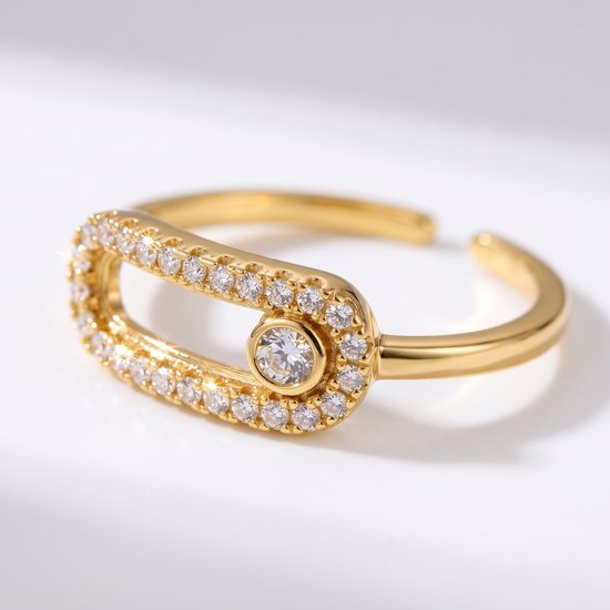 Bague dorée ajustable ornée de zircons, au design de broche de sûreté. La bague a une plus grande pierre au centre.