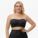 Volslanke vrouw met blonde krullen draagt een zwarte strapless BH met voorgevormde cups. Ze draagt een zwarte rok.