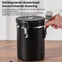 Close-up van een hand die de RVS maatlepel van de zwarte koffiebewaarpot haalt, die aan de zijkant hangt.
