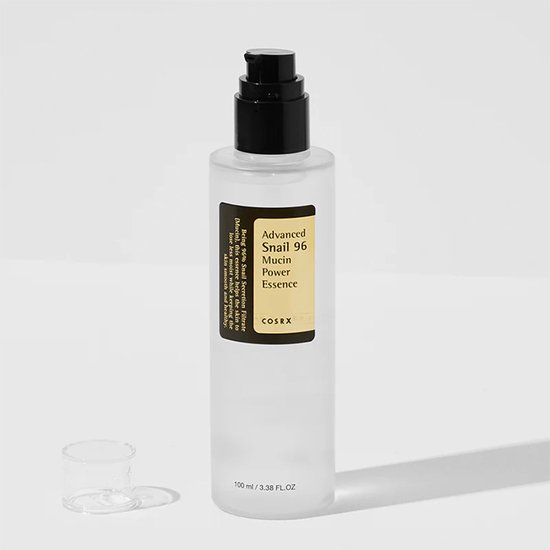 Fles COSRX Advanced Snail 96 Mucin Power Essence met losse dop naast de zwarte pomp.