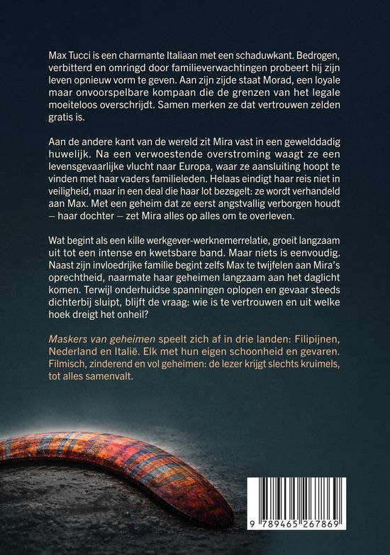 Boek 'Maskers van geheimen' met op de voorgrond een bruin bumerang met patronen. De achtergrond is zwart.