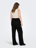 Een model, van achteren gezien, draagt een beige top en een zwarte wijde broek met elastische tailleband.