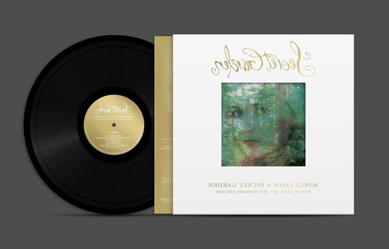 Zwarte vinylplaat naast een witte hoes met bosafbeelding en de tekst 'Songs from a Secret Garden 30th Anniversary Edition'.