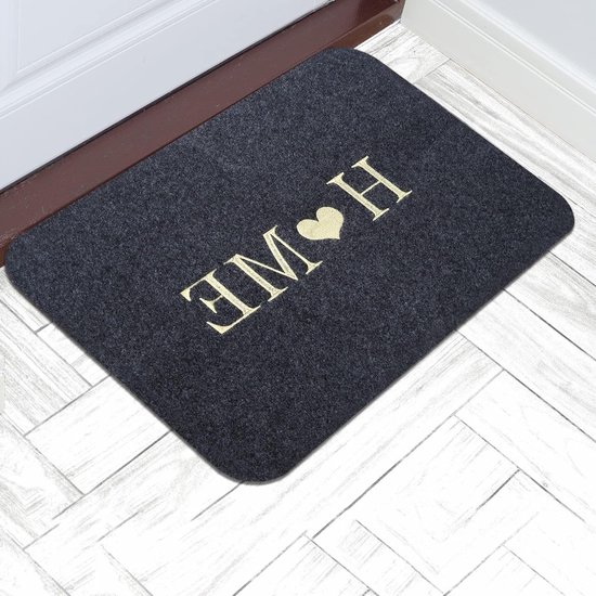 Paillasson sombre avec inscription dorée 'HOME' et cœur, devant une porte d'entrée.