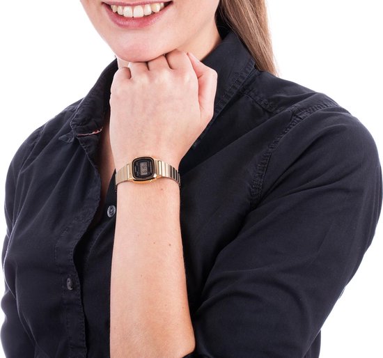 Vrouw met goudkleurig Casio dameshorloge met digitaal display om de pols.
