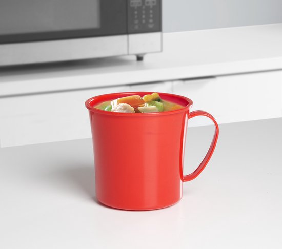 Tasse à soupe rouge Sistema remplie de soupe, sur un comptoir à côté d'un four à micro-ondes.