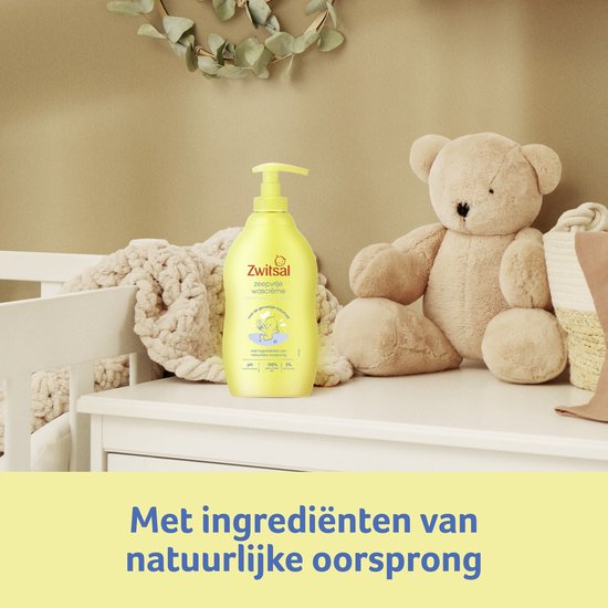 Zwitsal zeepvrije wascrème in gele pompflacon, naast een teddybeer op een kinderkamer commode.