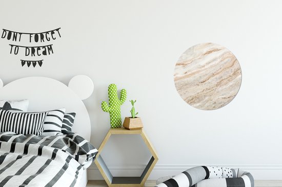 Ronde wanddecoratie met een marmerlook patroon in beige, bruin en wit tinten.