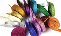 Groep opgerolde glitterveters in diverse kleuren zoals goud, paars, groen, rood en blauw.