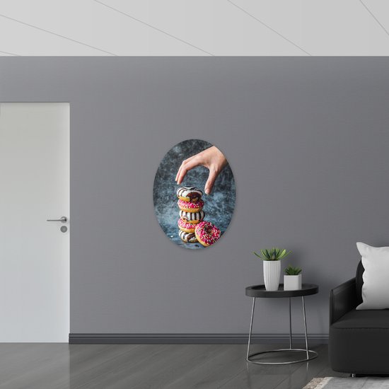 Dibond Ovaal - Donuts - Gestapeld - Sprinkels - Hand - Kleurrijk - 72x96 cm Foto op Ovaal (Met Ophangsysteem)