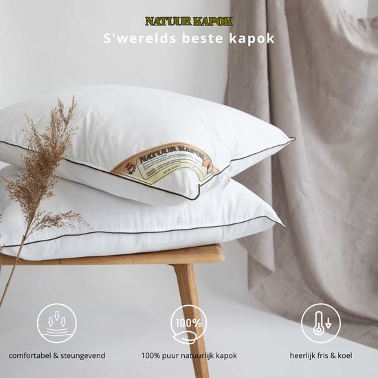 Twee witte kapok kussens op een houten krukje, met bruine biezen en een label met "Natuur Kapok".