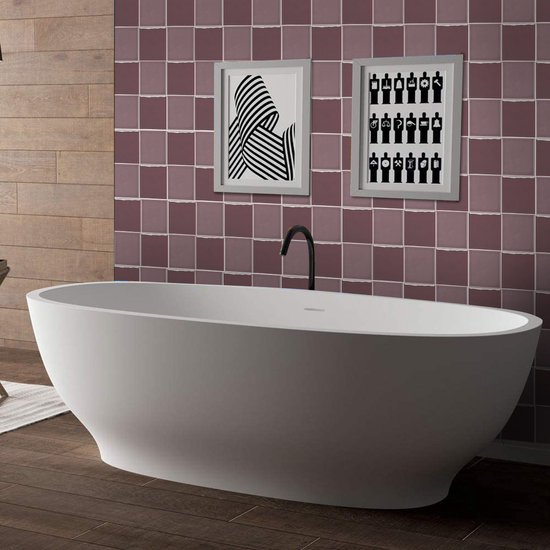 Salle de bain avec des carreaux lilas et violets sur le mur, une baignoire îlot et un plancher en bois.