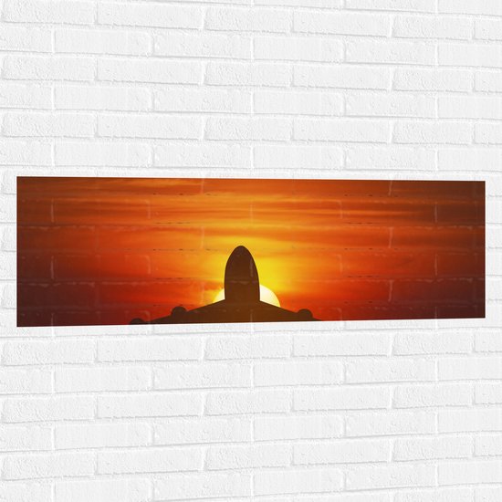 Muursticker - Silhouet van Vliegtuig tegen Feloranje Zon in Roodkleurige Lucht - 120x40 cm Foto op Muursticker