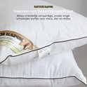 Twee witte kapok kussens opgestapeld, met bruine bies en Oeko-Tex label.