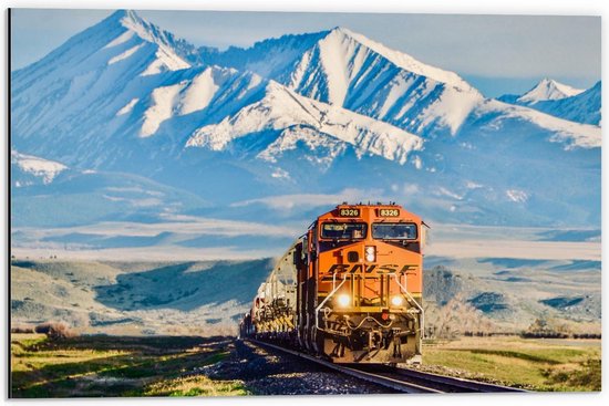 Dibond - Oranje Trein met Besneeuwde Bergen op de Achtergrond - 60x40cm Foto op Aluminium (Wanddecoratie van metaal)