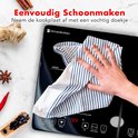 Hand veegt een zwarte inductie kookplaat schoon met een blauw-wit gestreept doekje. 'Eenvoudig Schoonmaken'.