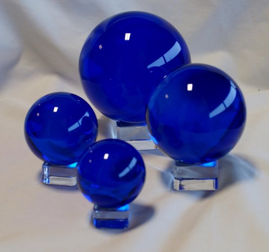 Deze glazen bol van hoogwaardig, doorschijnend blauw kristalglas heeft een diameter van 5 cm met glazen voetje Feng Shui  geluksbrenger