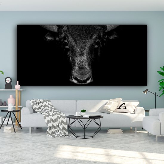 Toile noir et blanc d'une tête de taureau sur fond noir. Le taureau regarde droit devant.