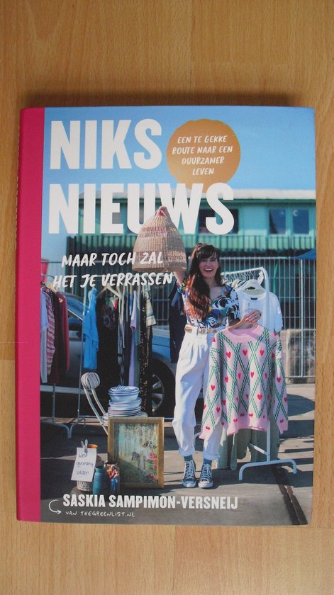 Vrouw met lang bruin haar, die een gebreide trui met hartjes vasthoudt voor een kleerrek.