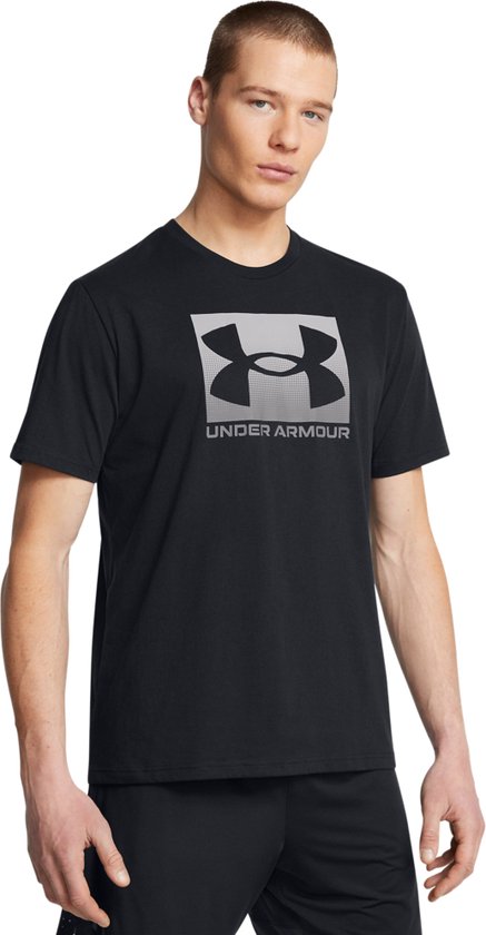 Man met zwart T-shirt met groot grijs Under Armour logo op de voorkant.