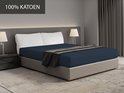 Drap-housse bleu foncé sur un lit avec le texte '100% COTON'.