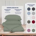 Gevouwen groen satijnen dekbedovertrek en kussenslopen met verticale strepen, met informatie over maten en kleuren.