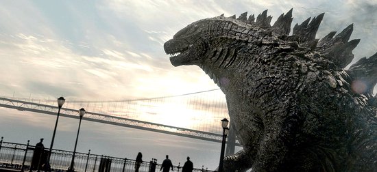 Godzilla, een enorm prehistorisch monster, staat op een kade met op de achtergrond een brug en de zonsondergang.