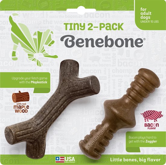 Een verpakking van twee Benebone hondenspeeltjes, een in de vorm van een tak en een in de vorm van een bot, beide met bacon smaak.