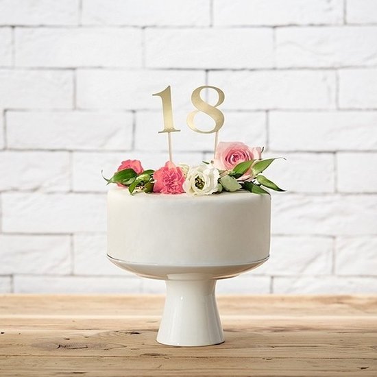 Gouden taartcijfer '18' op een witte taart, versierd met roze en witte bloemen.