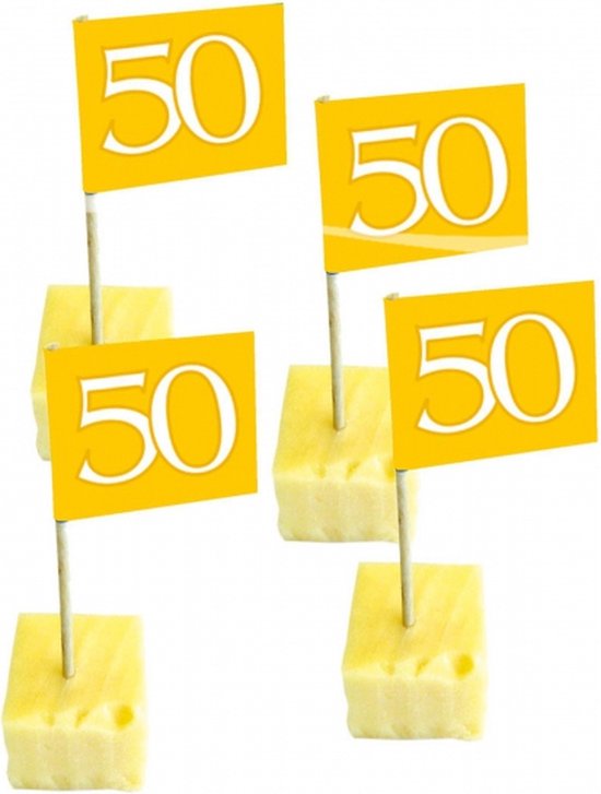 Vier gouden vlaggetjes met het getal '50' erop, gestoken in blokjes ananas.