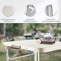 Zilverkleurige campingtafel met waterkoker, met tekst over hoogwaardig oppervlak.