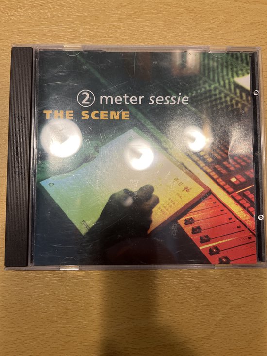 CD hoes met "2 meter sessie THE SCENE" tekst, een mengpaneel en papier met aantekeningen.