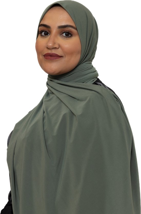 Model met een bleekgroene jersey hoofddoek die losjes om de schouders valt.