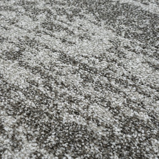 Gedetailleerde close-up van de textuur van een grijs vloerkleed met een gemêleerd patroon.