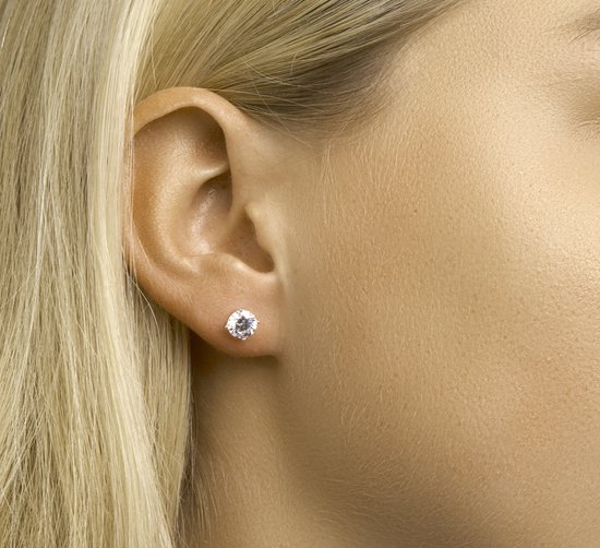Zilveren oorknop met heldere zirkonia, 6 mm. Gedragen door model met blond haar.