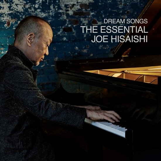 Een man speelt op een piano met de tekst 'DREAM SONGS THE ESSENTIAL JOE HISAISHI' op de achtergrond.